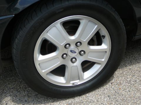 1999 Mercury Grand Marquis - A close-up view of a car's wheel and tire, showing a Ford emblem on the hub.