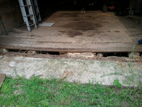 1985 Ford F-150 - The floor of a barn or garage shows damage and a ladder leaning against the wall.