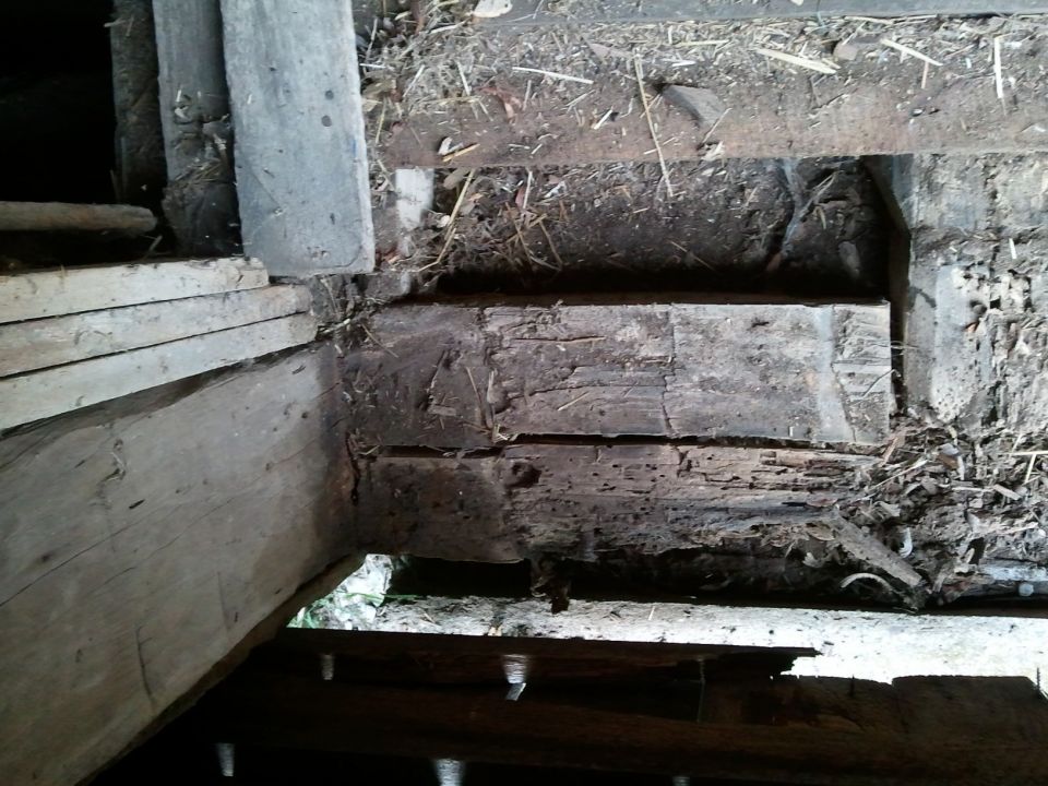 Wooden beams and debris in a dark, possibly dilapidated structure. Text 'SUPERMOTORS' visible at bottom right