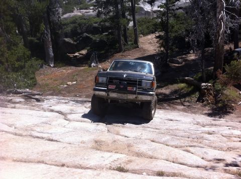 1990 Ford Bronco - Ford Bronco tackling a challenging rocky off-road path.