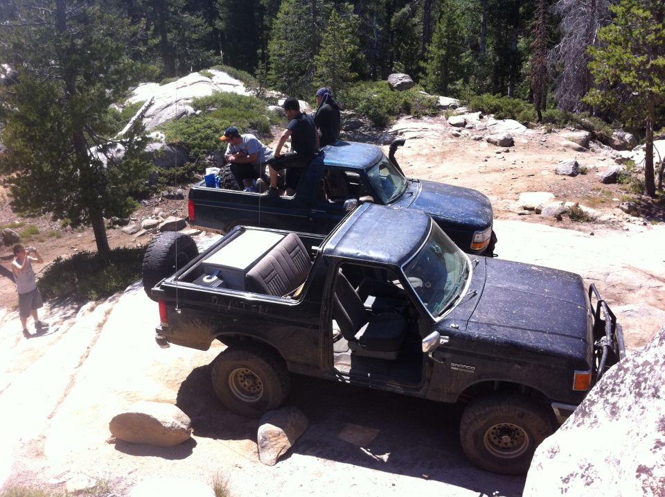 1990 Ford Bronco parked on rocks, doors open, seats in back