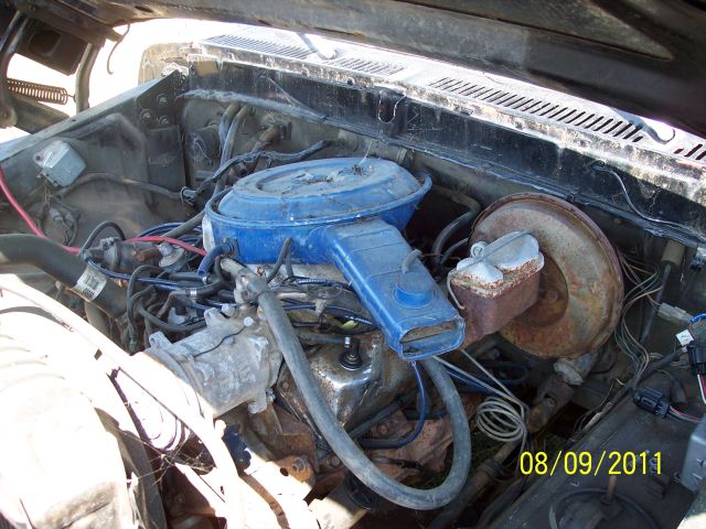 engine bay with blue air cleaner assembly and brake booster