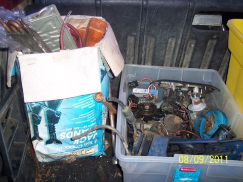 1978 Ford Bronco - Assorted vehicle parts are stored in a plastic bin and a cardboard box.