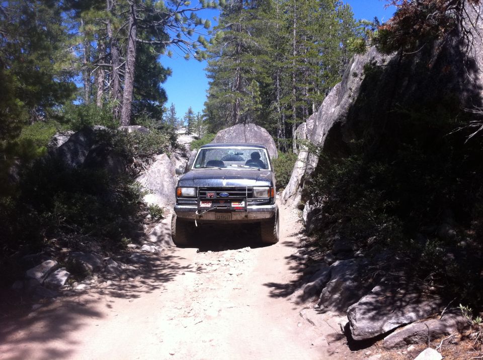 1990 Ford Bronco front view on a rocky off-road trail
