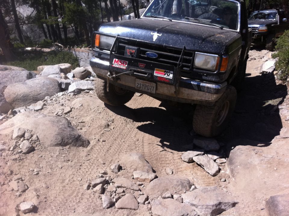 1990 Ford Bronco on rocky trail, front view with bull emblem on hood