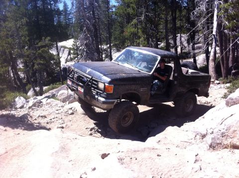 1990 Ford Bronco - Ford Bronco tackling a challenging off-road course in the mountains.