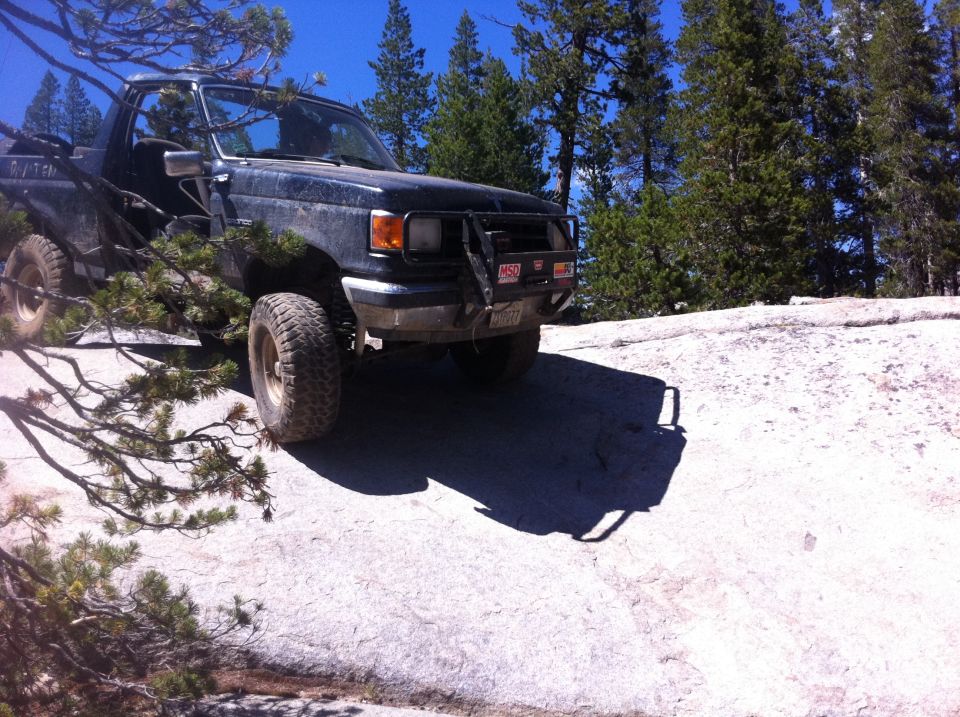 1990 Ford Bronco with off-road tires on rocky terrain