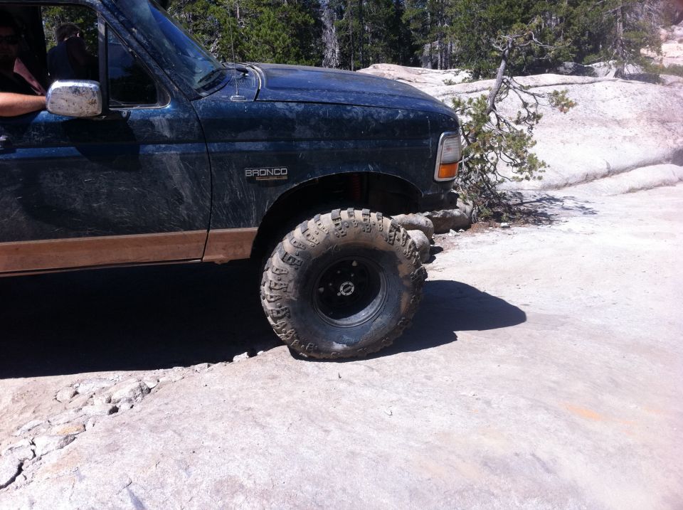 1990 Ford Bronco on rocky terrain, driver visible in window