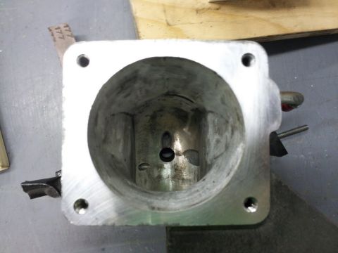 2000 Mercury Grand Marquis - Close-up view of a metal throttle body, showing its internal structure and a central opening.