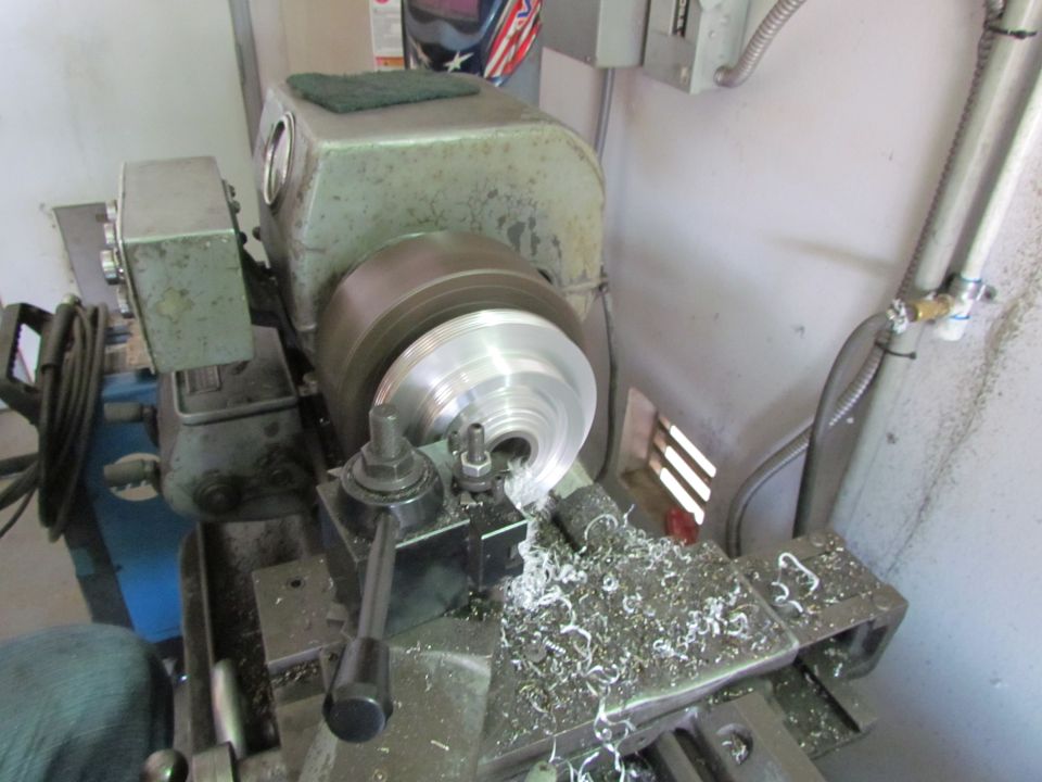 Metal lathe cutting metal shavings from a round part on the chuck