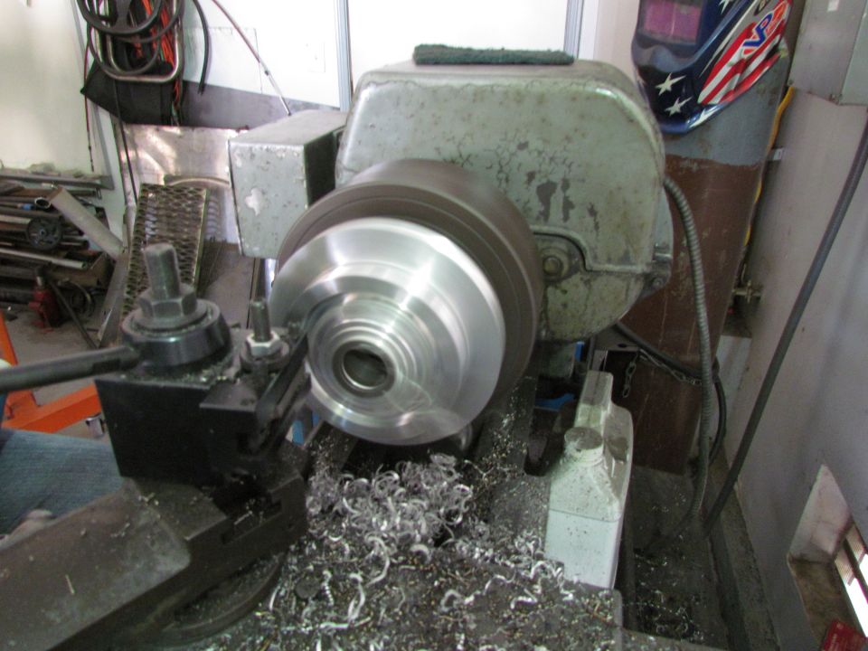 Brake rotor on a lathe with curled metal chips piled below