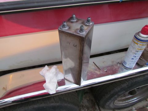 1995 Ford Probe - A custom metal fuel tank with four fittings and handwritten markings sits on a vehicle's fender next to a can of spray paint.