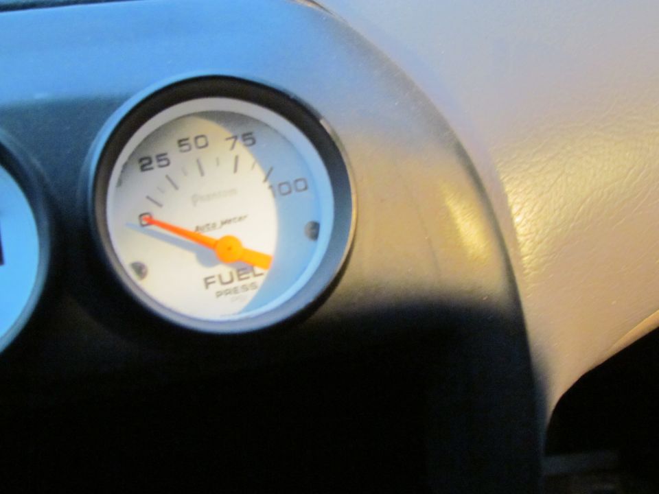 Close-up of a fuel pressure gauge on a car's dashboard. The gauge reads about 40 PSI