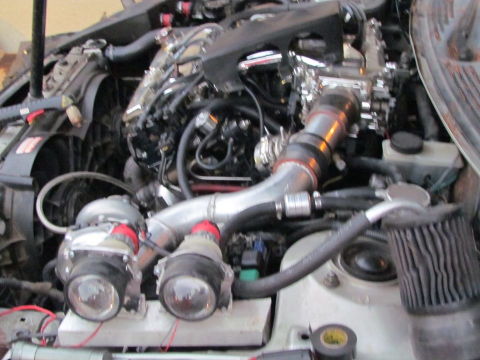 Engine bay with twin turbochargers, intercooler piping, and air filter. Some wiring is visible