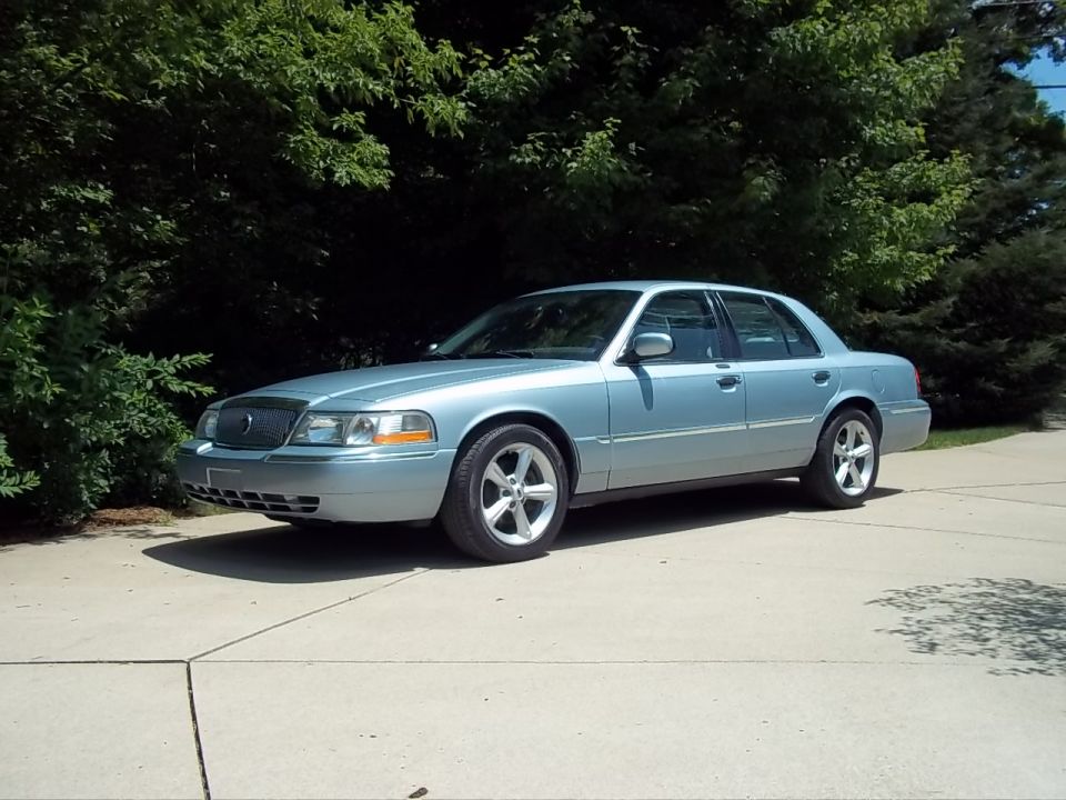 Light blue 2003 Mercury Grand Marquis sedan parked on concrete driveway
