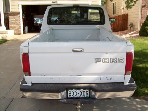 1993 Ford F-150 - Rear view of a white Ford pickup truck with a chrome bumper and tailgate.