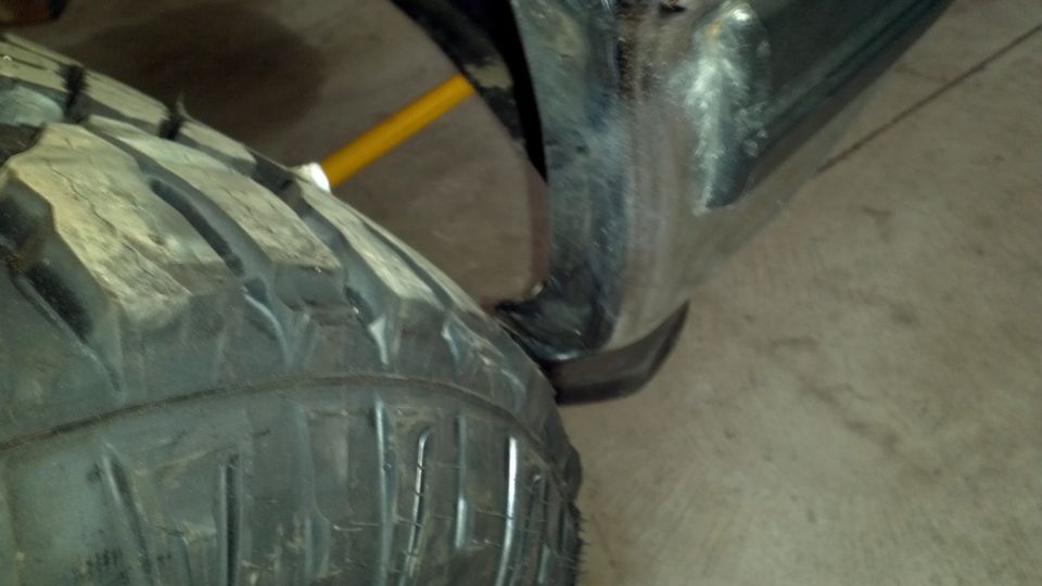 Tire and black fender flare with yellow support rod