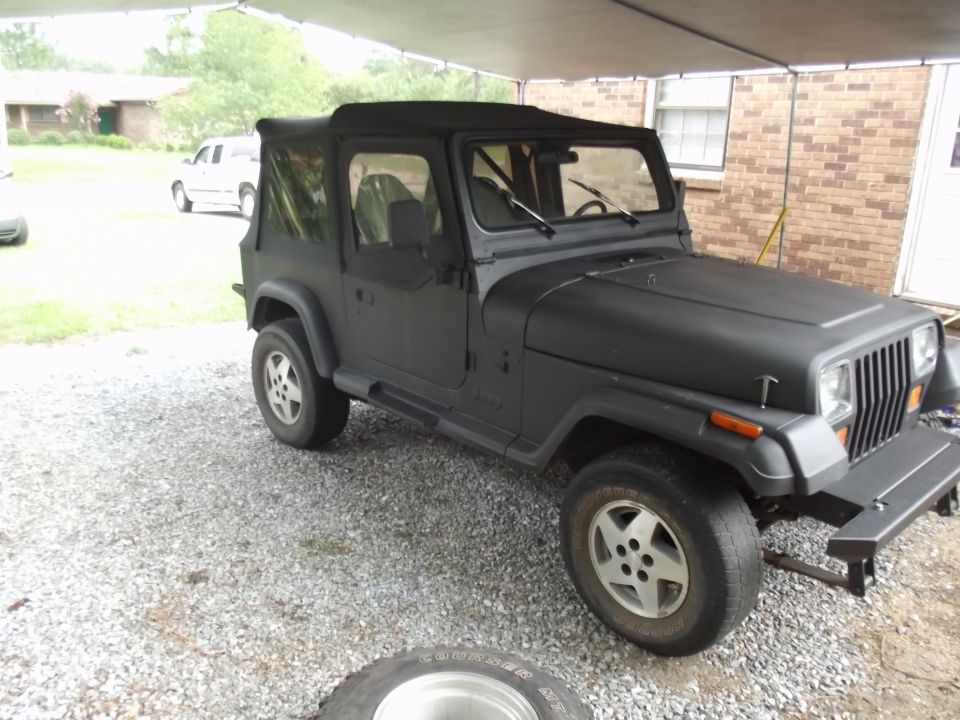 Black 1993 Jeep YJ with soft top, viewed from front three-quarter angle