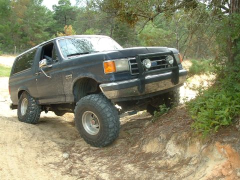 1995 Ford Bronco - This lifted 1992 Ford Bronco navigates a sandy and rocky off-road path.