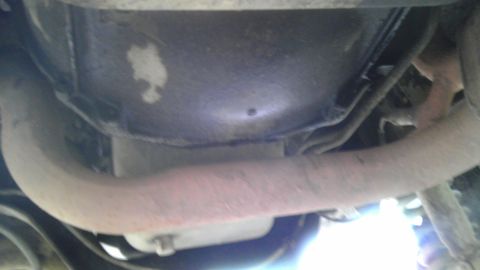1989 Ford Bronco - Close-up view of the undercarriage, focusing on the exhaust pipe and surrounding components.