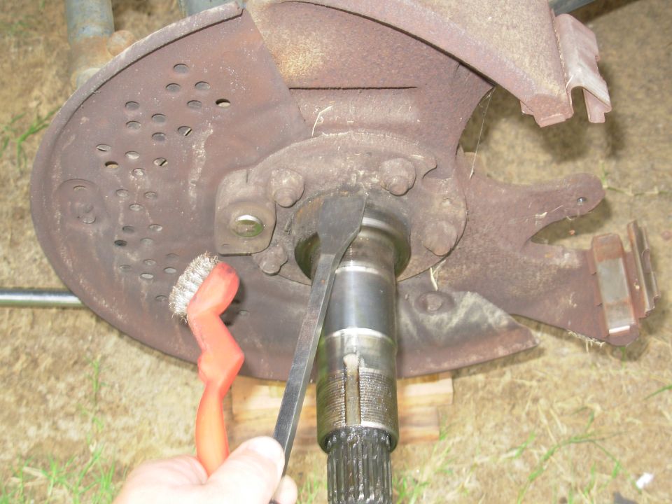 Splined axle shaft and dust shield with wire brush during front-end work