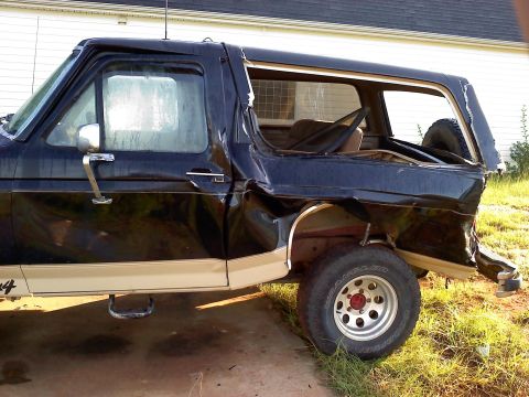 1989 Ford Bronco - This heavily damaged Ford Bronco shows extensive rear-end collision impact.