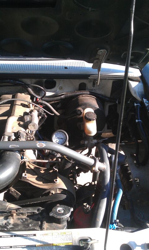 1992 Ford Ranger - The engine bay of a 1992 Ford Ranger shows the brake booster, master cylinder, and a pressure gauge.