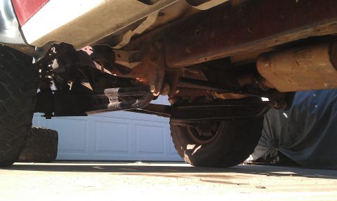 1992 Ford Ranger - The underside of a truck shows its suspension components and exhaust system, with a garage door in the background.
