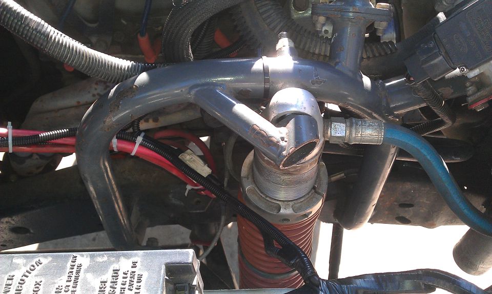 Close-up of engine hoses and wiring, with a Supermotors.net watermark