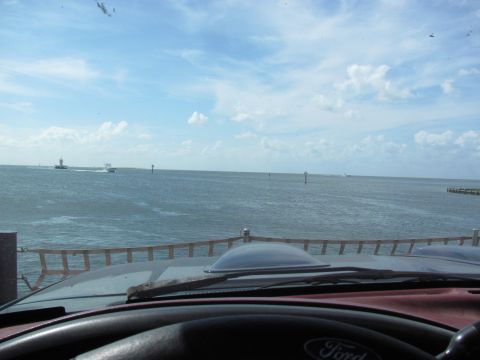 1995 Ford Bronco - View from inside a vehicle shows a body of water with boats and a lighthouse under a cloudy sky.