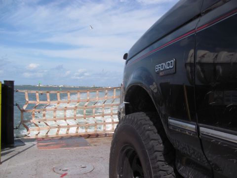 1995 Ford Bronco - Bronco XL on ferry crossing water with distant land visible.