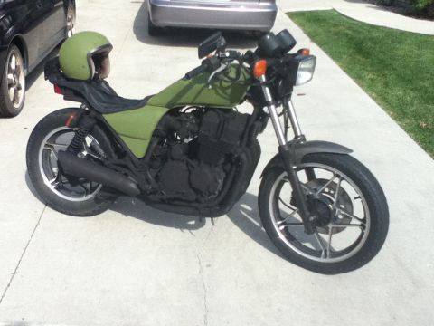 2002 Kawasaki Ninja - Motorcycle with a green helmet on the seat, parked outdoors on a concrete driveway.