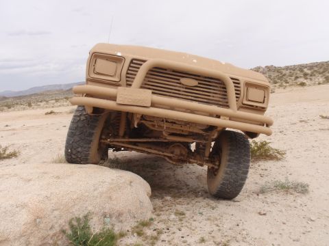 1978 Ford Bronco - Tan 1978 Ford Bronco navigating rocky desert terrain.