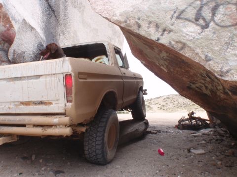 1978 Ford Bronco - Brown 1977 Ford F-Series truck with a dog in the bed, parked under a rock overhang.