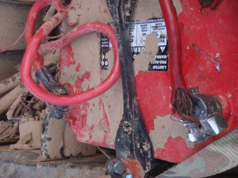 1978 Ford Bronco - The battery and its red cables are covered in dirt and dust, showing signs of heavy use.