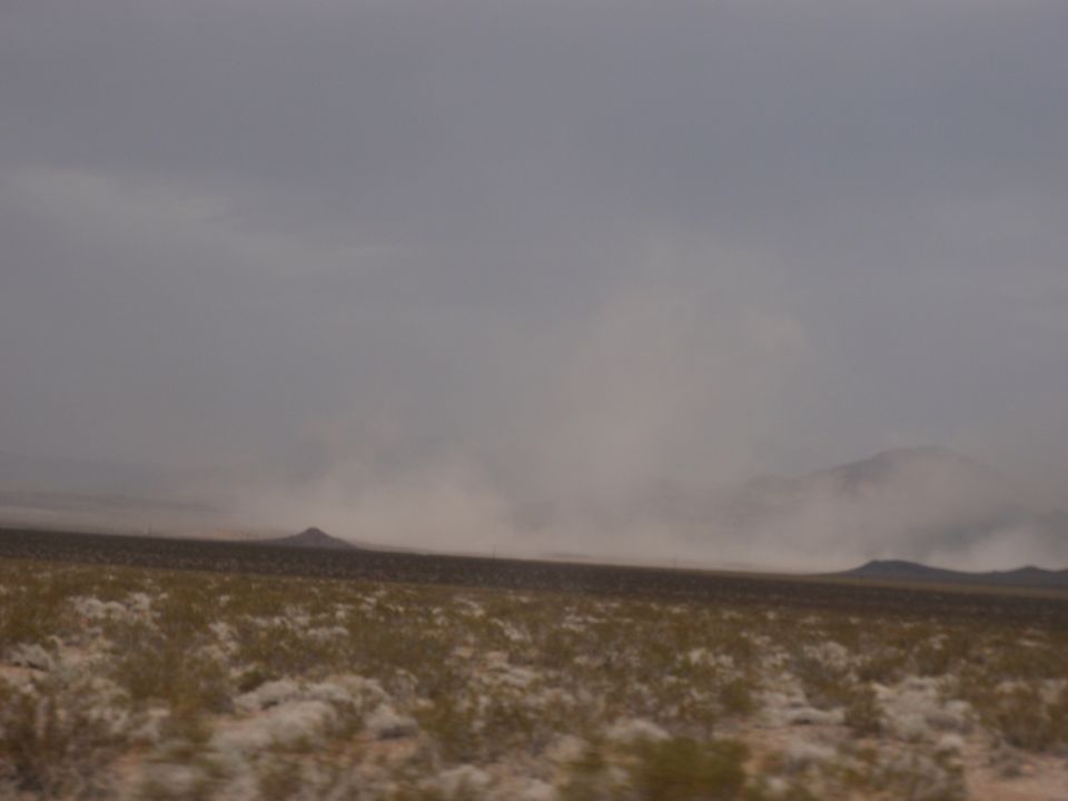 Desert landscape with a dust storm obscuring distant mountains and hills
