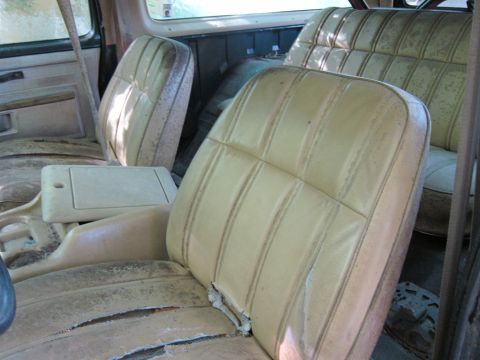 1991 Ford LTD Crown Victoria - Interior view of a vehicle's tan seats, showing significant wear and tear on the upholstery.