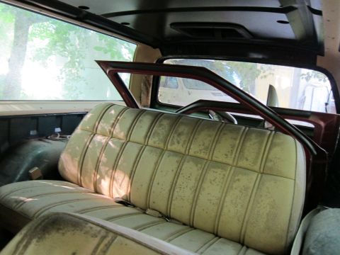 1991 Ford LTD Crown Victoria - Interior of a car with dirty seats and a visible roll cage structure.
