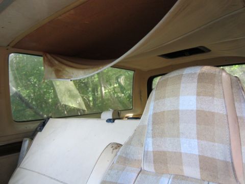 1991 Ford LTD Crown Victoria - The interior of a car features a sagging headliner and tan and white plaid upholstery on the seats.