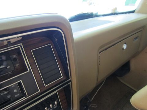 1991 Ford LTD Crown Victoria - Close-up of a car's tan dashboard, showing the glove compartment and air vent details.