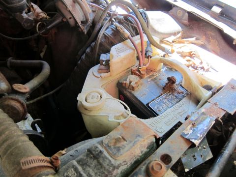 1991 Ford LTD Crown Victoria - Close-up of a vehicle's engine bay, focusing on the battery and coolant reservoir.