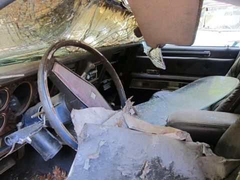 1991 Ford LTD Crown Victoria - The interior of a car is heavily damaged with a broken windshield and steering wheel.