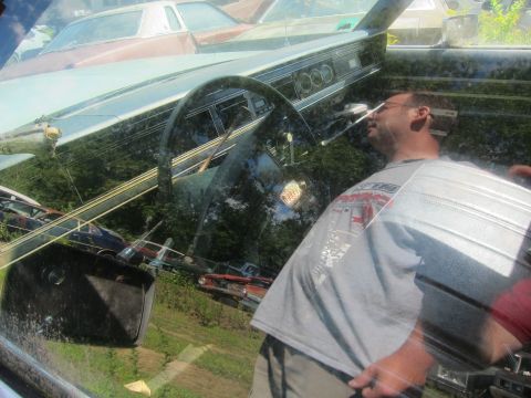 1991 Ford LTD Crown Victoria - Interior of a car, likely from the 1970s, with reflections of other vehicles and a person.