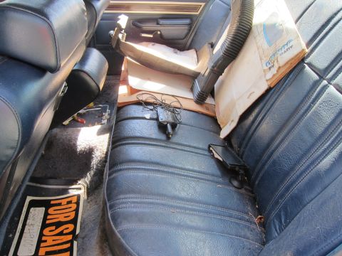 1991 Ford LTD Crown Victoria - The interior of a car shows a "FOR SALE" sign and various items on the seats.