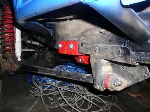1979 Ford Bronco - Close-up view of the undercarriage, highlighting custom red suspension components and a blue roll cage.