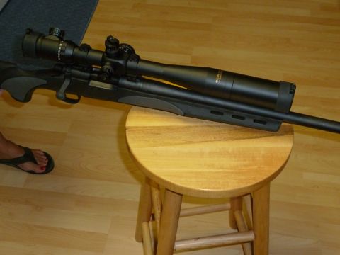 1992 Ford Mustang - A rifle with a large scope is displayed on a small wooden stool.