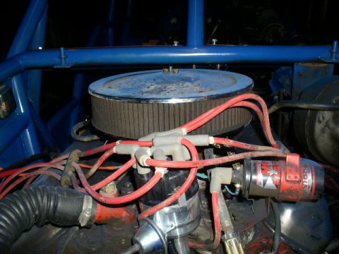 1979 Ford Bronco - Close-up of an engine bay with various components and blue roll cage structure visible.