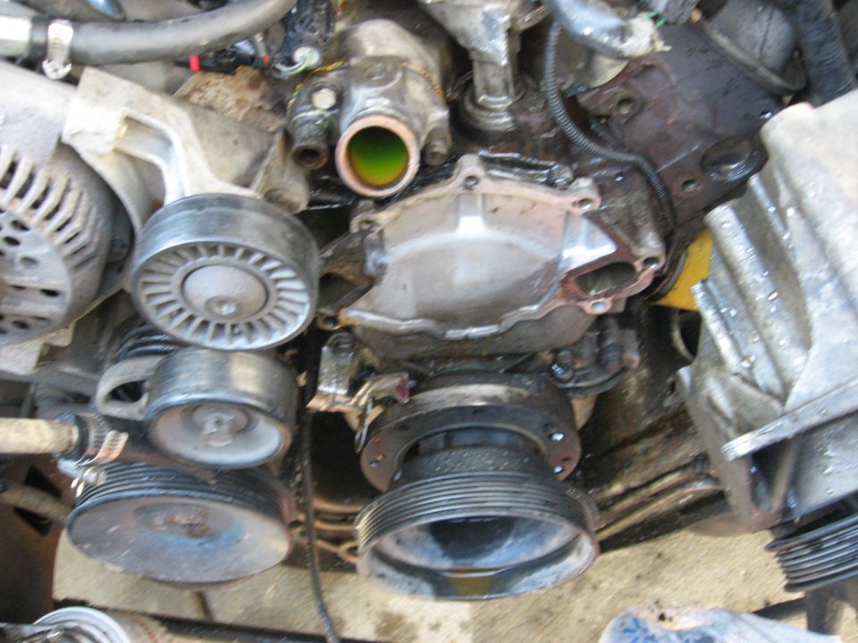 Engine front with water pump, crank pulley and idler exposed during belt-driven accessory work
