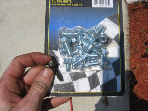 1994 Ford Bronco - A hand holds a single bolt from a package of oil pan bolts for Ford 289-351W, AMC & Olds V-8 engines.