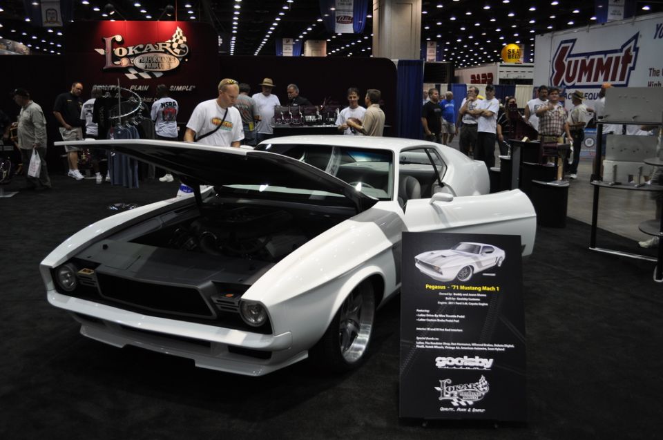 White 1971 Ford Mustang Mach 1 with hood open, parked indoors at a car show